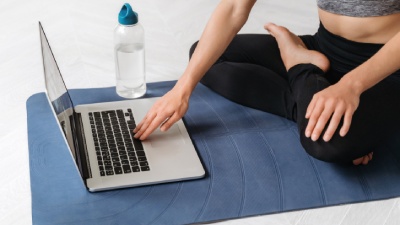 Frau auf Matte vor Laptop