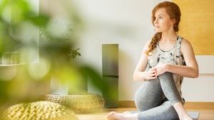 Frau macht Yoga zuhause
